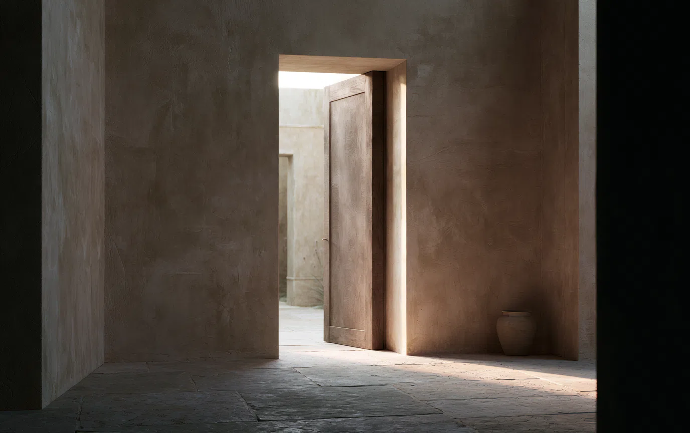 A softly illuminated timber doorway opening into a calm, light-filled interior